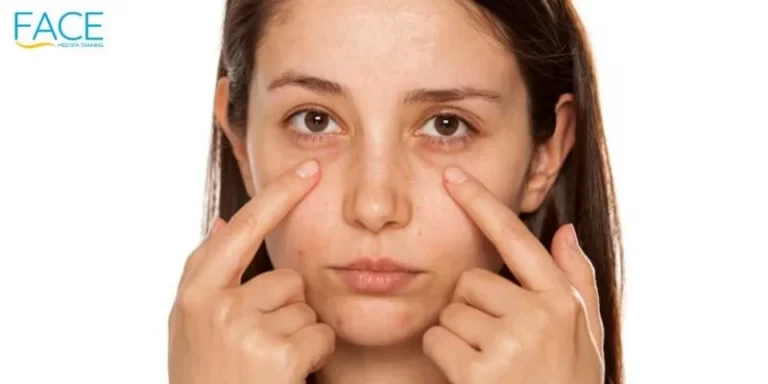 Beautiful young woman touch her face under eyes on white background