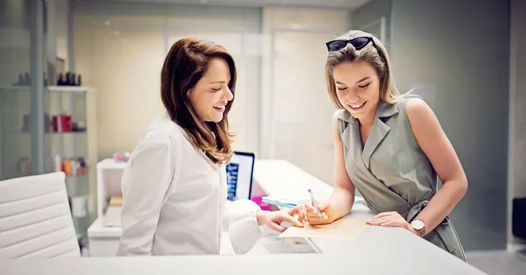 Young woman is filling documents on the beauty treatment clinic reception