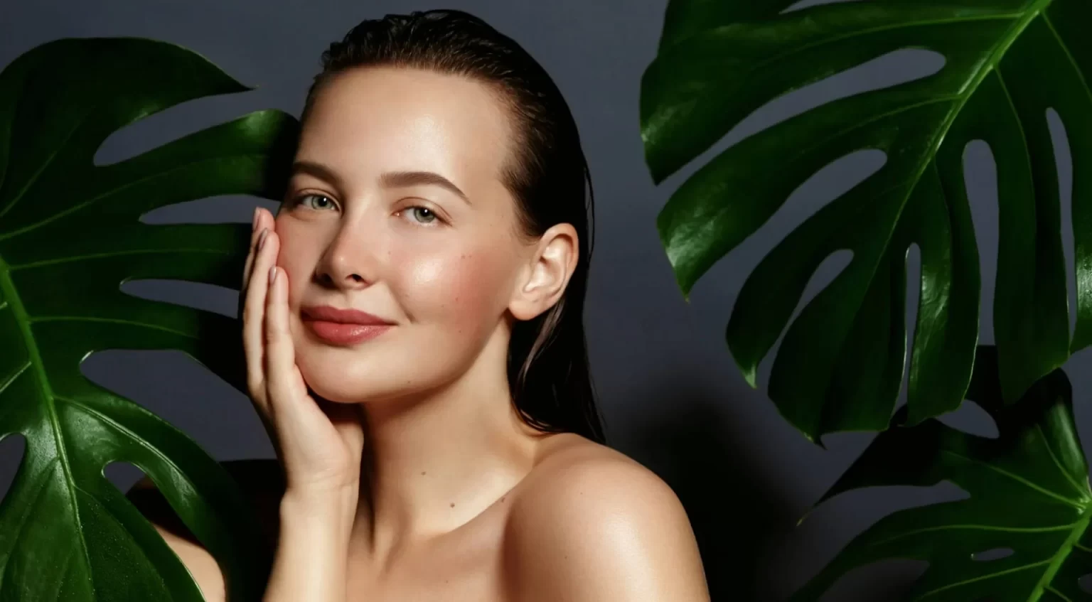 young woman portrait with fresh green exotic tropical leafs