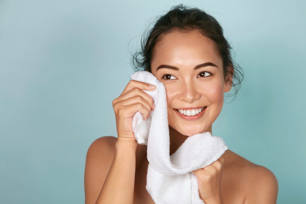 Closeup of woman cleaning skin with towel