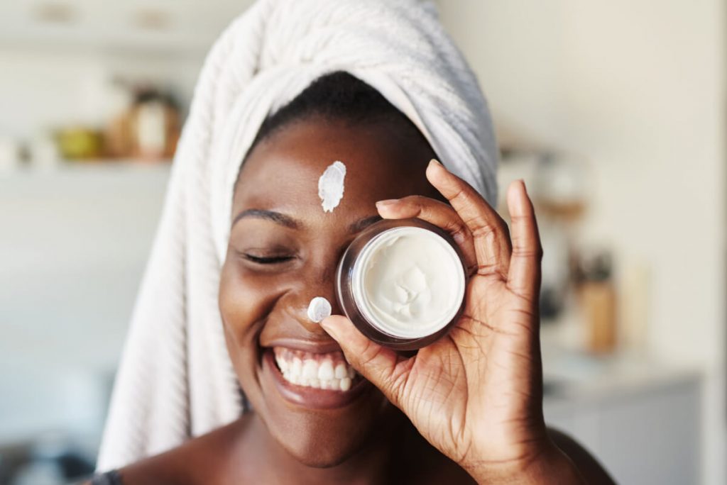 Shot of a beautiful young woman holding up a face cream product