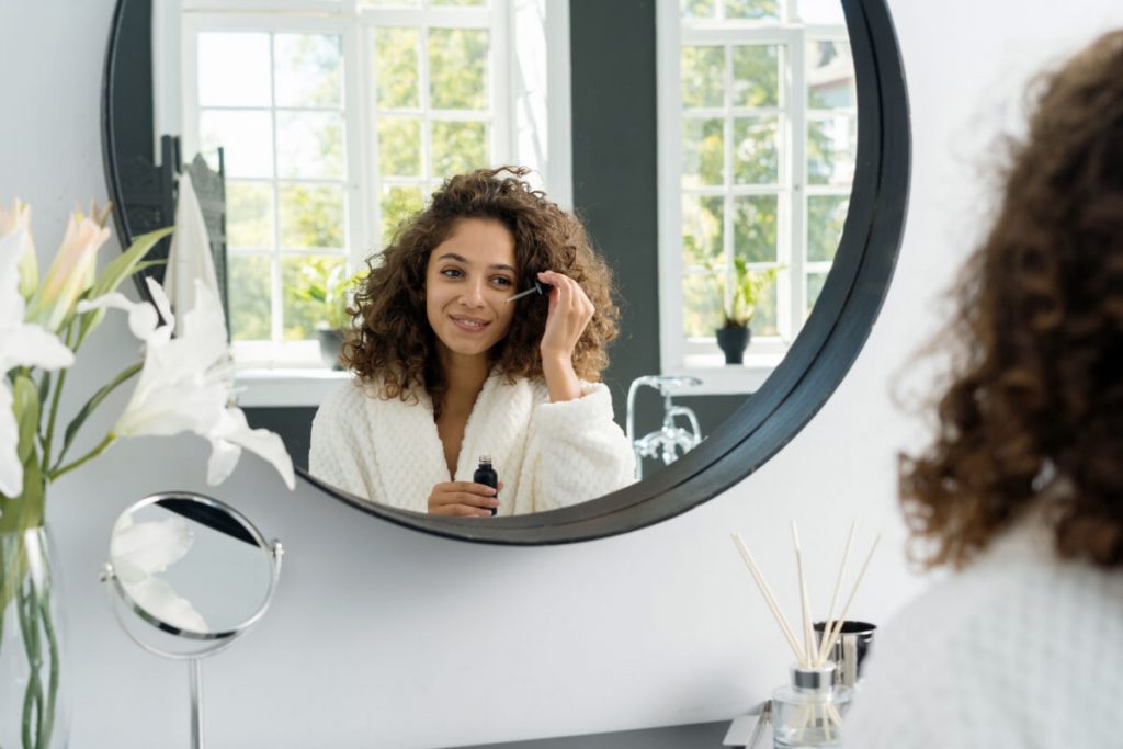 Young adult african american woman in bathrobe at bathroom