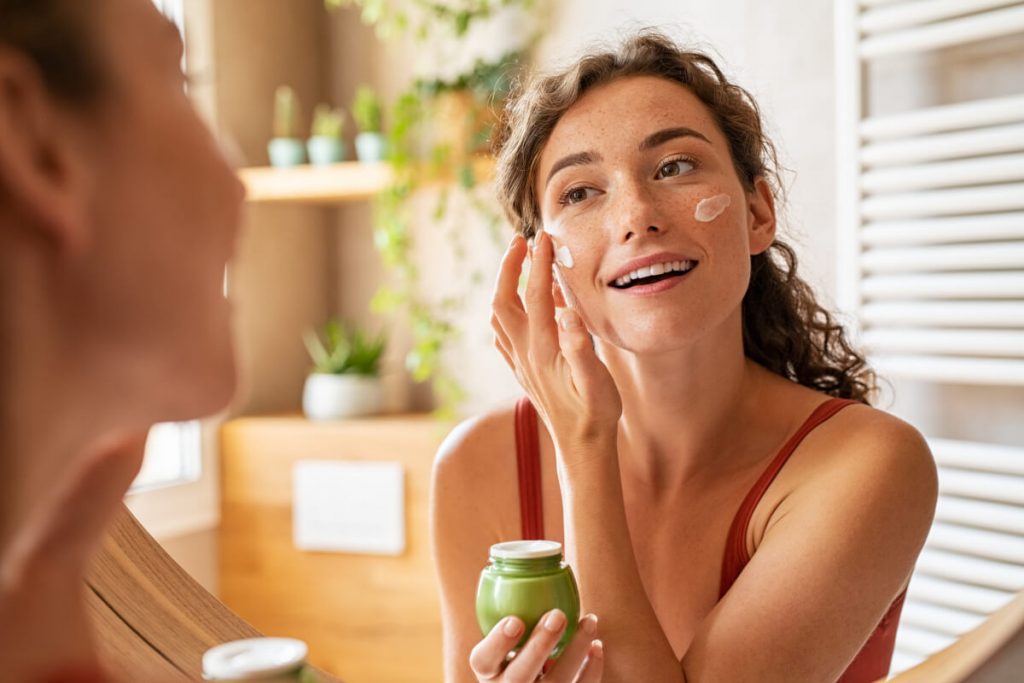 woman applying moisturiser on face