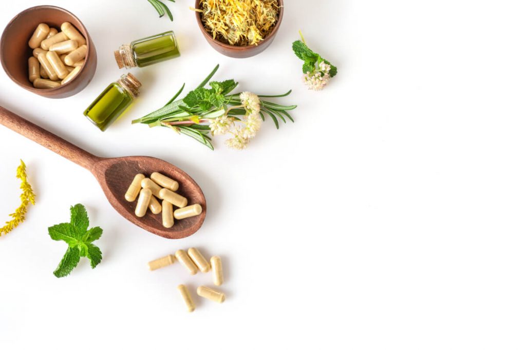 Various medicinal herbs and herbal pills isolated on white background