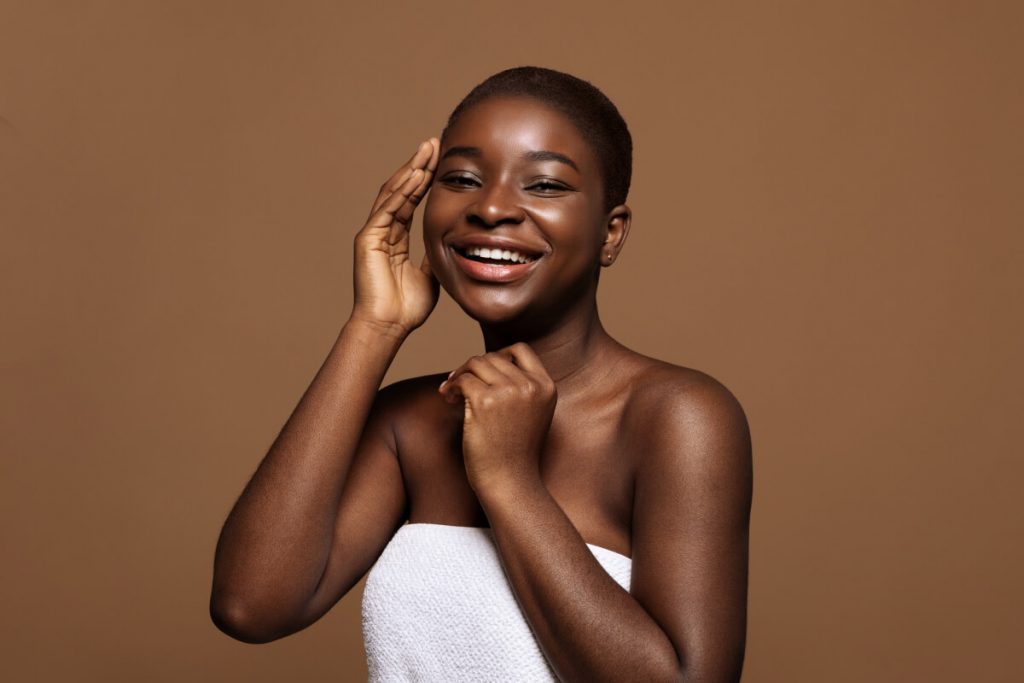 Joyful African American Lady With Short Hair Touching Her Soft Skin