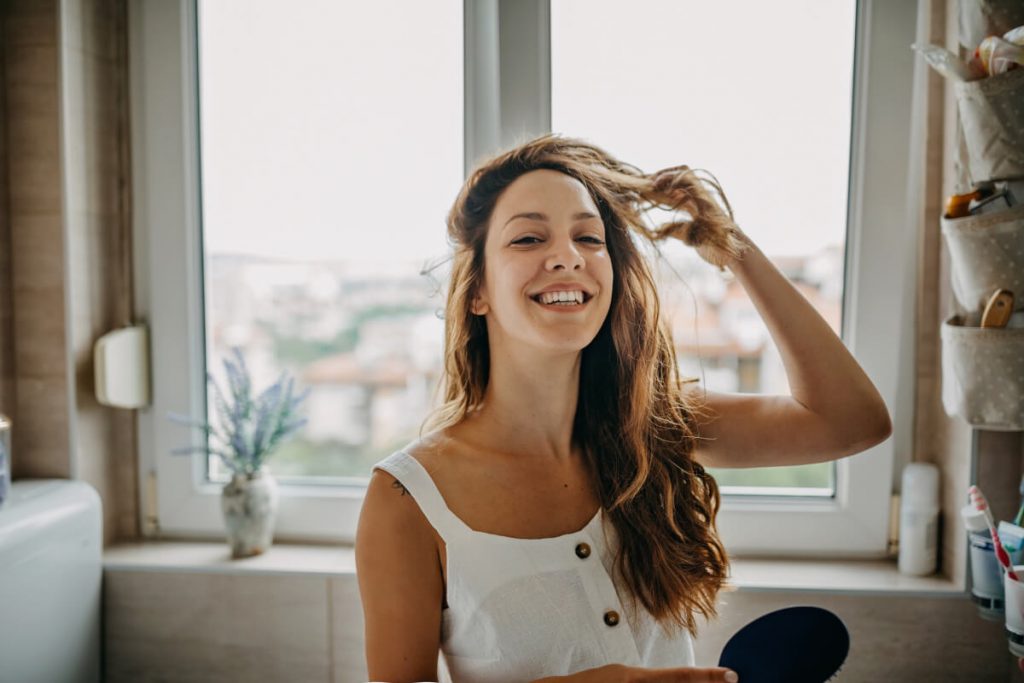 Young woman combing hair