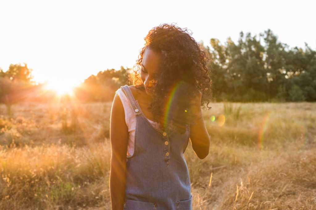 portrait outdoors of a beautiful young afro american woman at sunset.