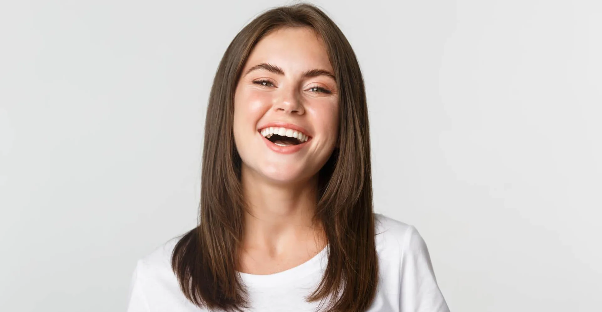 lose up of happy brunette girl in white t-shirt laughing and smiling carefree at camera