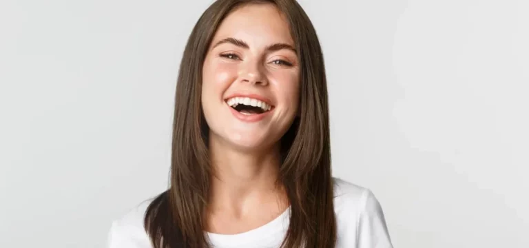 lose up of happy brunette girl in white t-shirt laughing and smiling carefree at camera