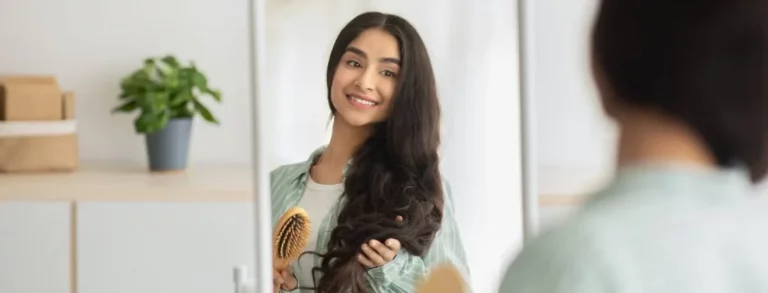 Cheerful young beautiful Indian woman in front of a mirror