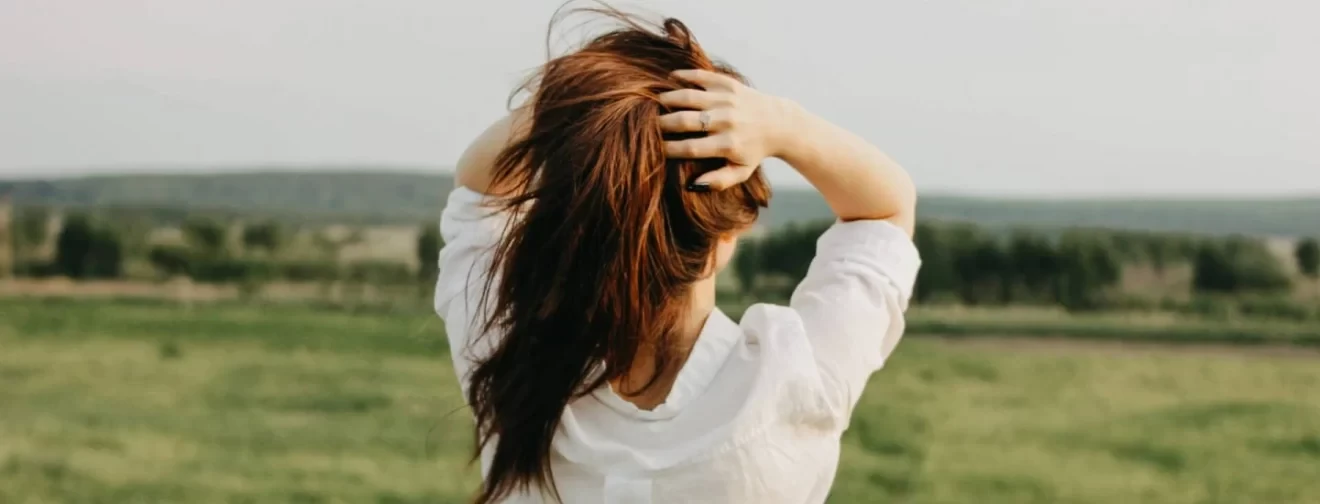 Beautiful carefree long hair girl in white clothes enjoys life in the nature field