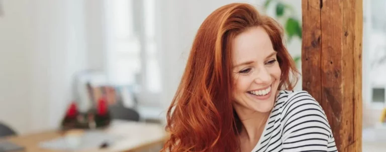 Laughing carefree young woman indoors at home