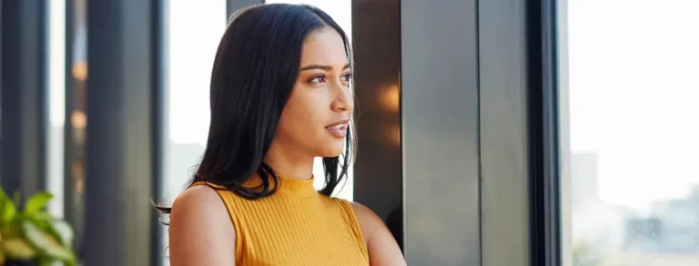 Shot of a young business woman looking thoughtfully out of a window