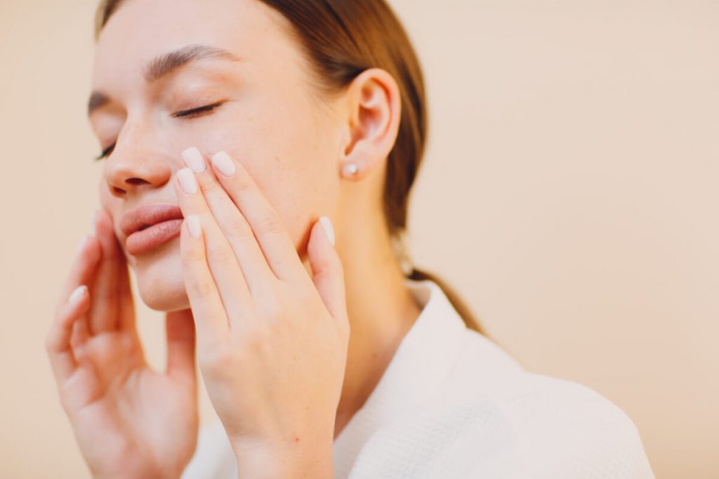 woman touching her face after PRP Facial