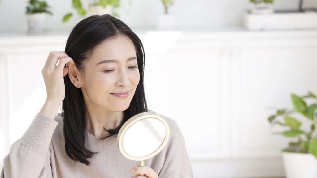 Asian middle woman touching hair