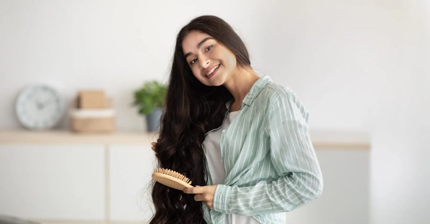 Portrait of lovely Indian lady brushing her wavy long hair,