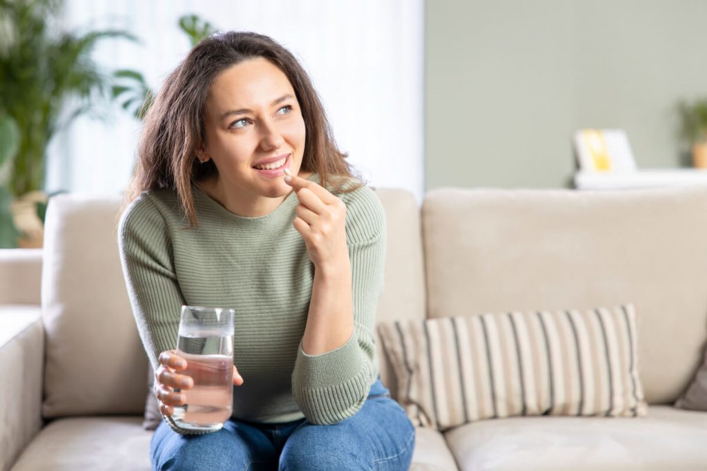 woman takes Anti-Inflammatories pill with a glass of water