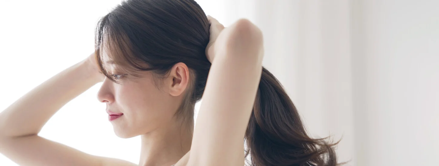 Young asian woman tying her hair after PRP treatment