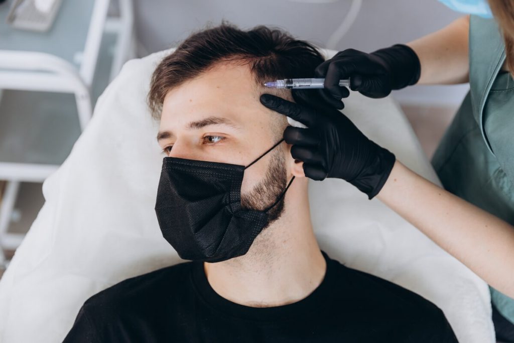 attractive man receives PRP injections to treat hair loss