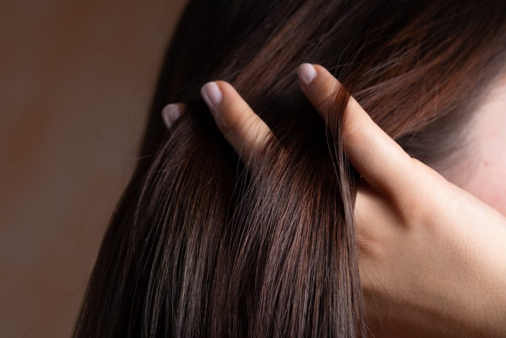 woman combing her fingers through the straight hair after prp therapy