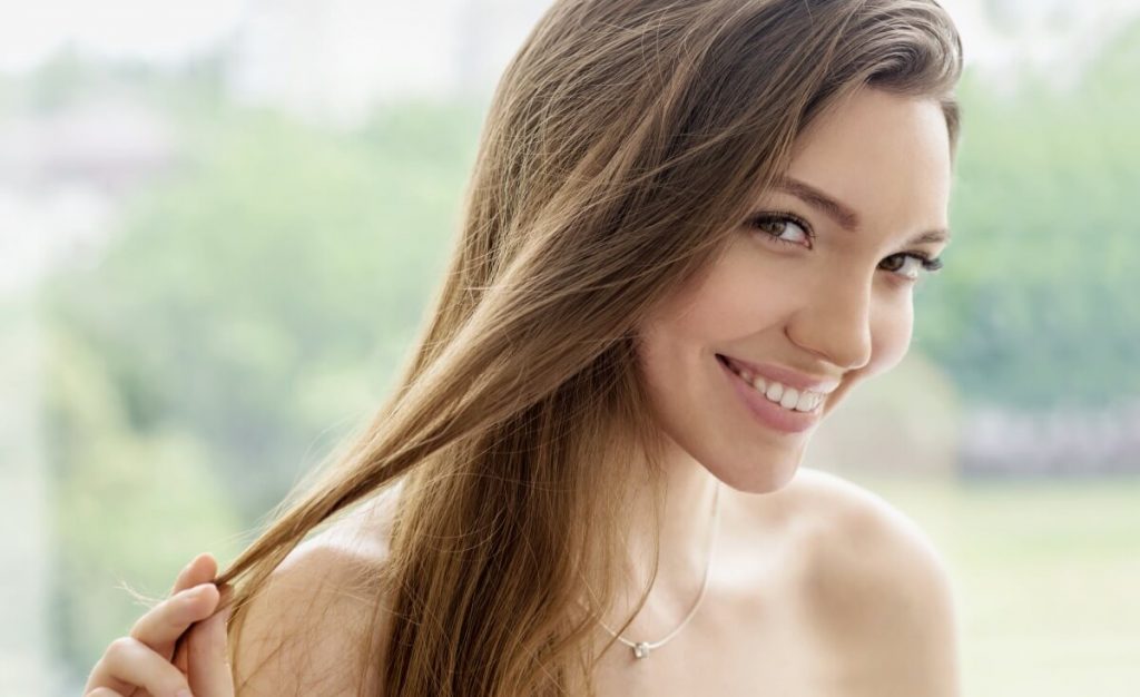 woman with long brown hair smiling after prp treatment