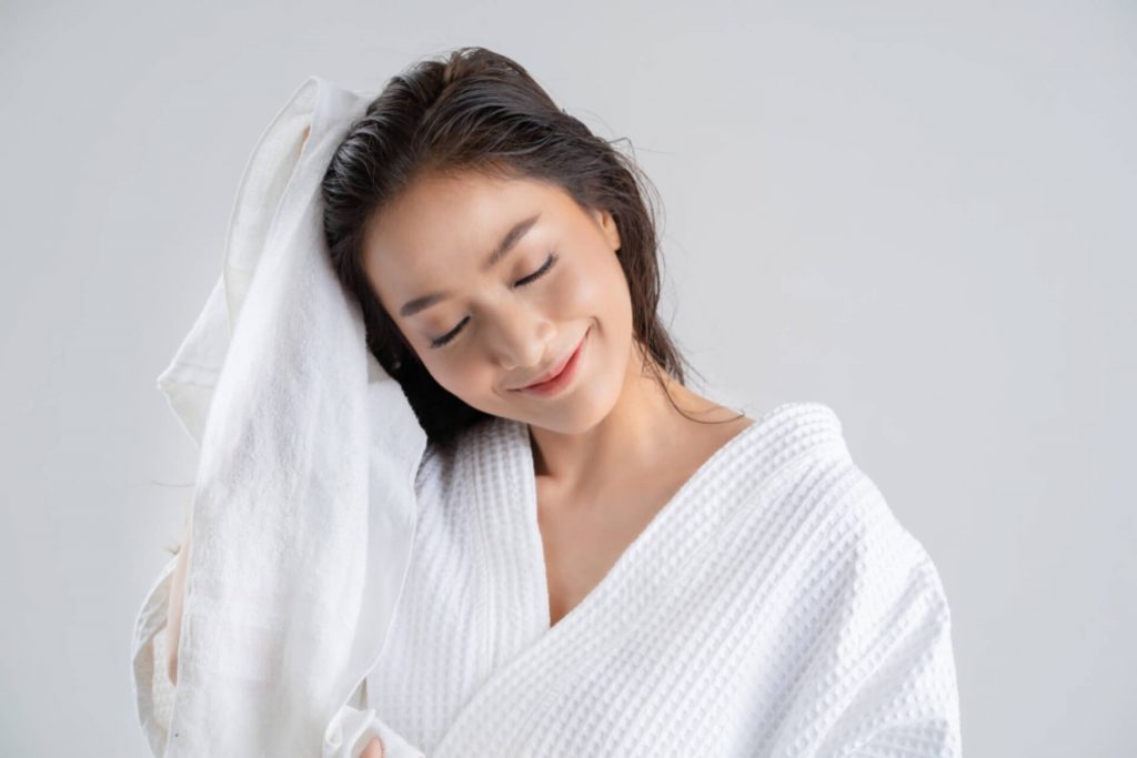 women are using a dry towel to dry their hair