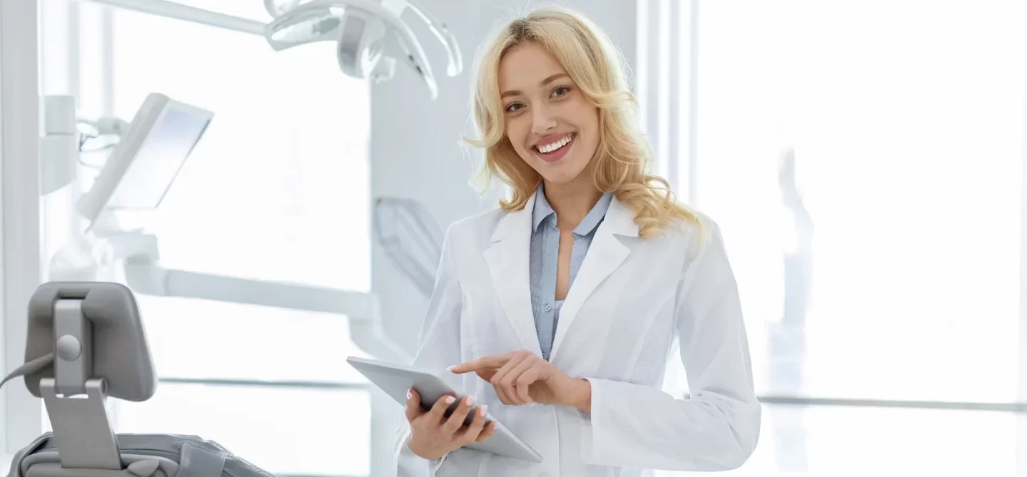 A smiling lady dentist standing facing the camera
