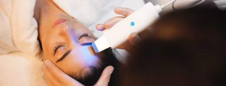 A woman's face receiving laser treatment