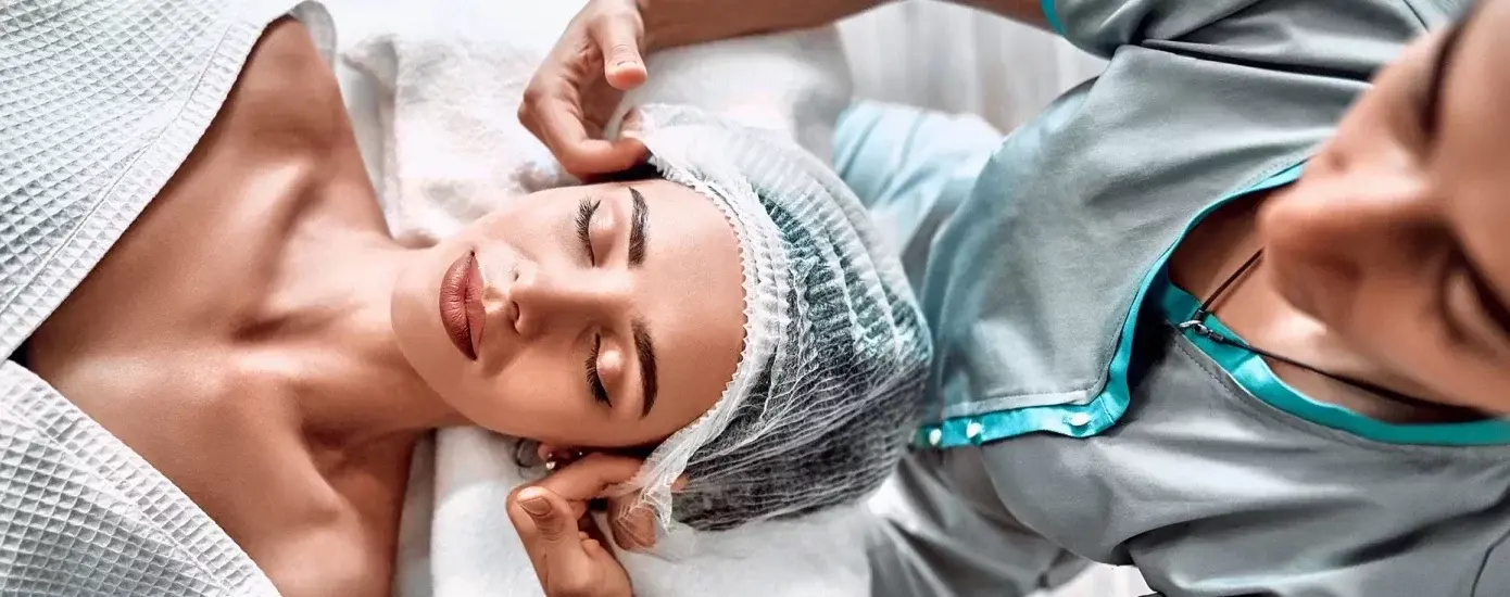 Woman lying on a medical couch and getting ready to receive aesthetics treatment.