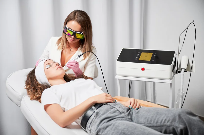 Esthetician performing laser treatment in clinic