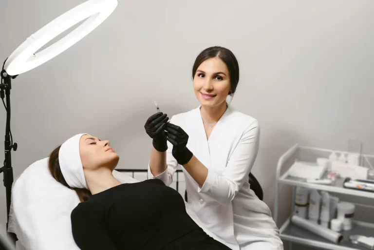 an aesthetician performs a dermal filler treatment on a client