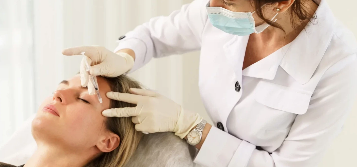 Medical esthetician gives botox treatment to her patient