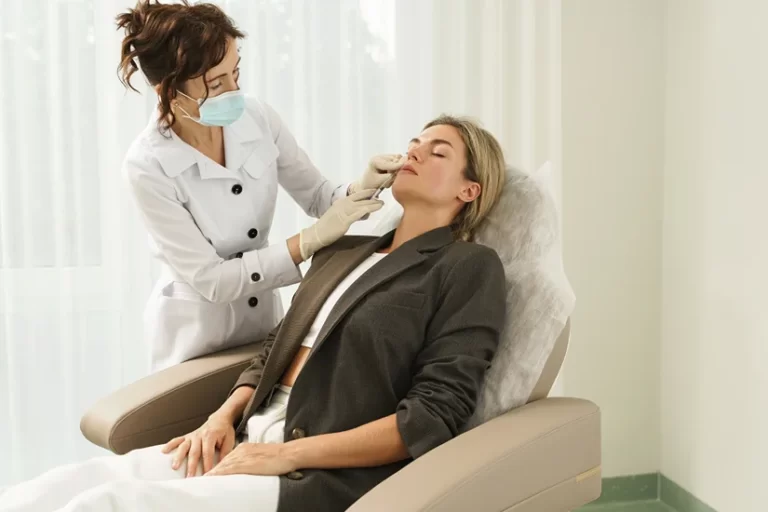 Esthetician and woman client during laser skin resurfacing treatment in a medical aesthetic clinic.