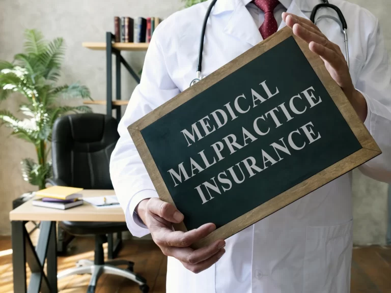 Doctor with the blackboard written Medical malpractice insurance.