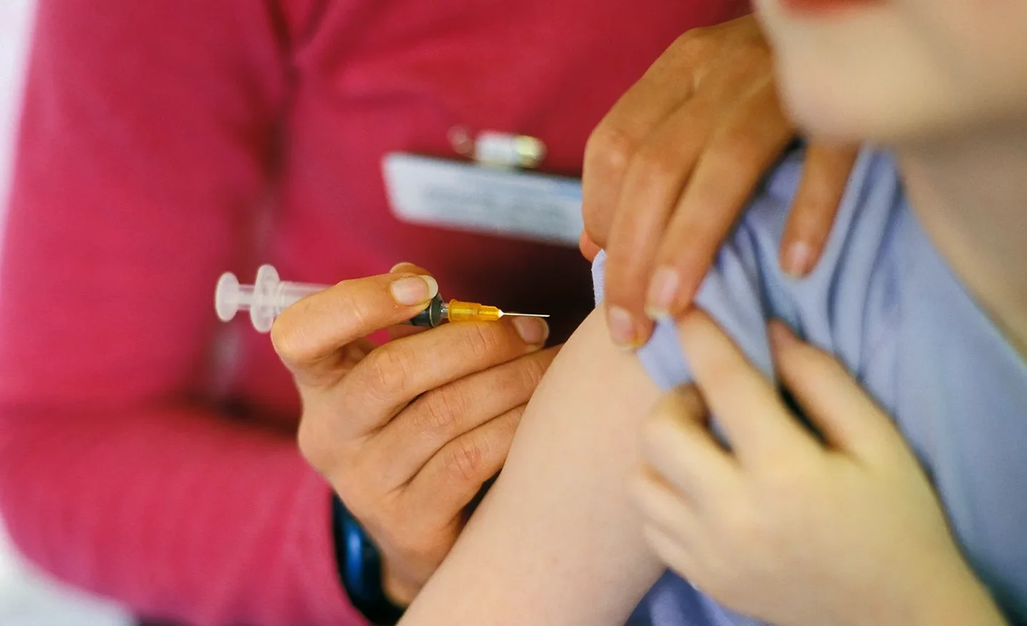 a medical professional vaccinated a child using a syringe with hypodermic needle