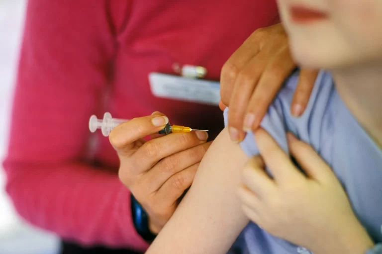 a medical professional vaccinated a child using a syringe with hypodermic needle