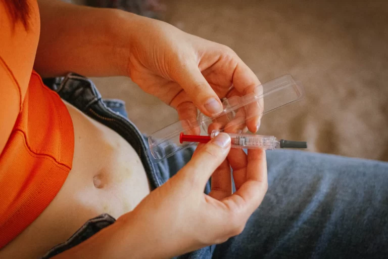 a woman unwrap a syringe with hypodermic needle