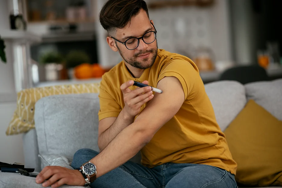 a man administers semaglutide pen injection on his upper arm