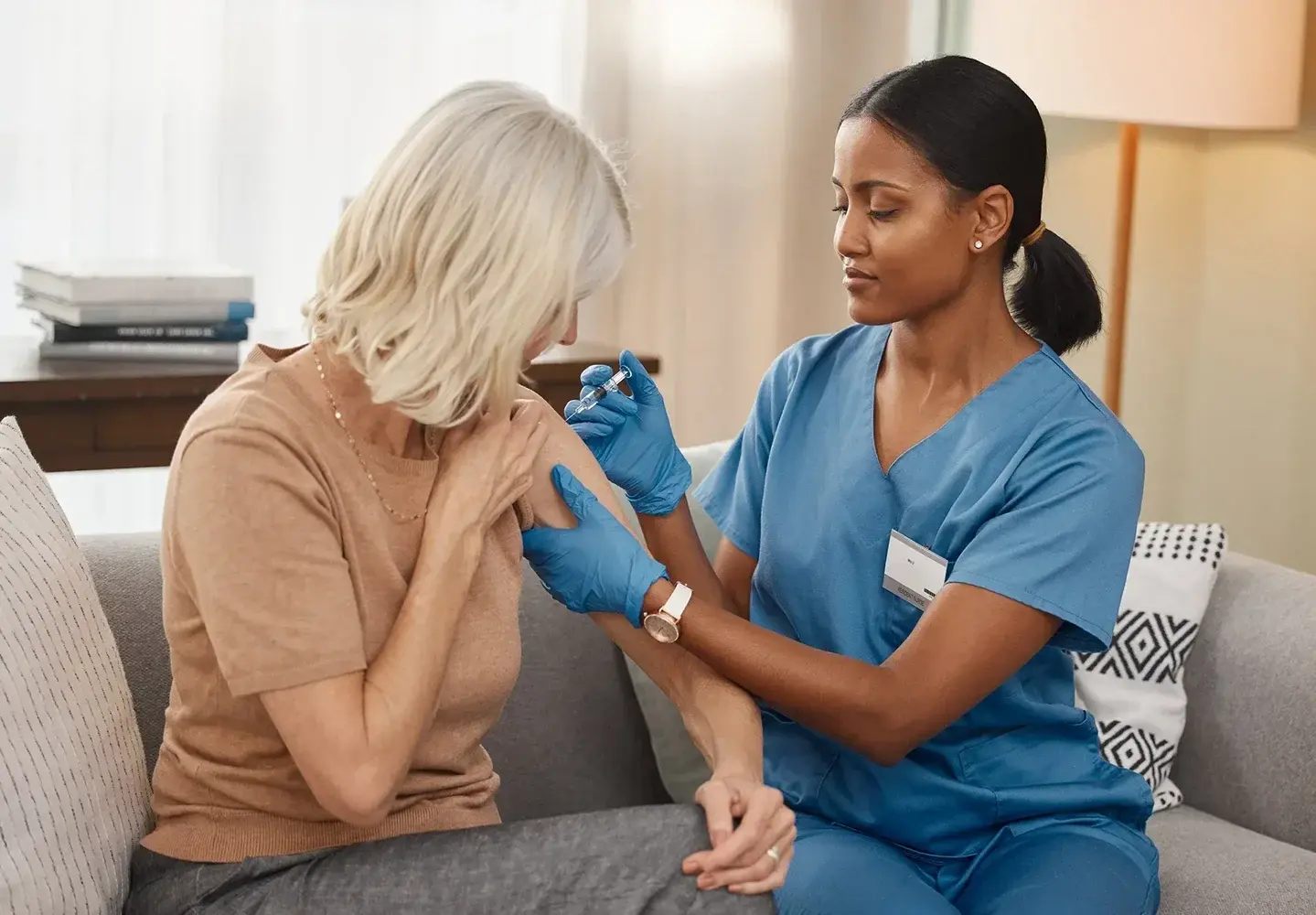 a nurse injects medication the patient's upper arm