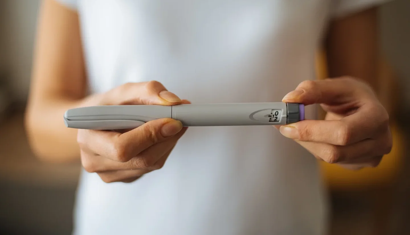 a woman winding up a dosage oh her semaglutide pen