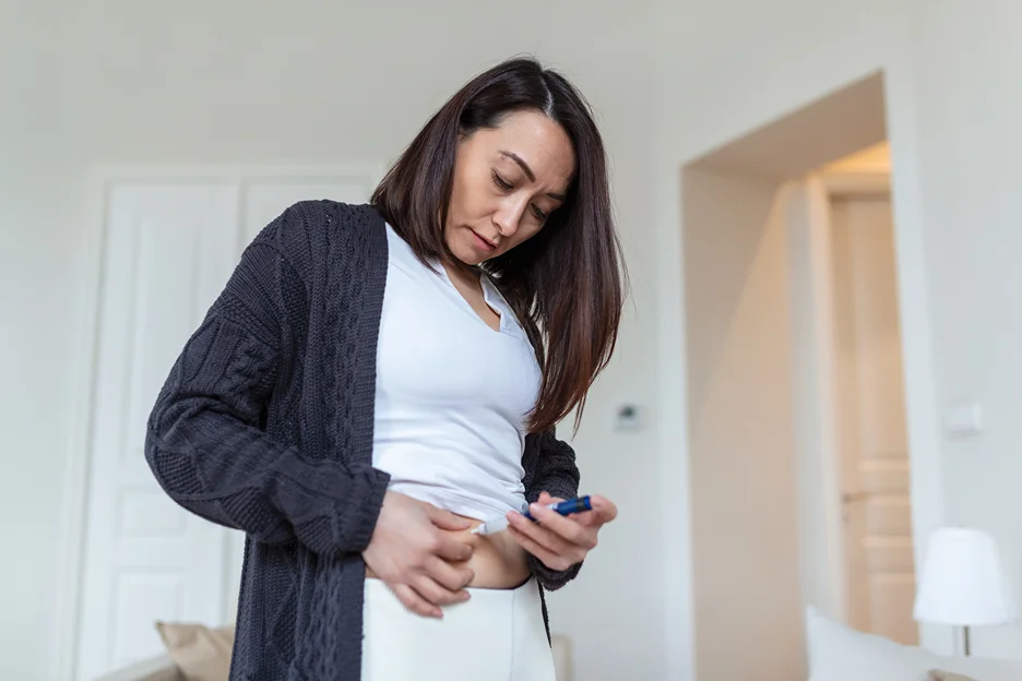 a woman self-injects with tirzepatide medication