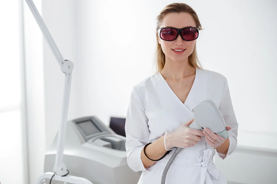 an esthetician holding a laser device