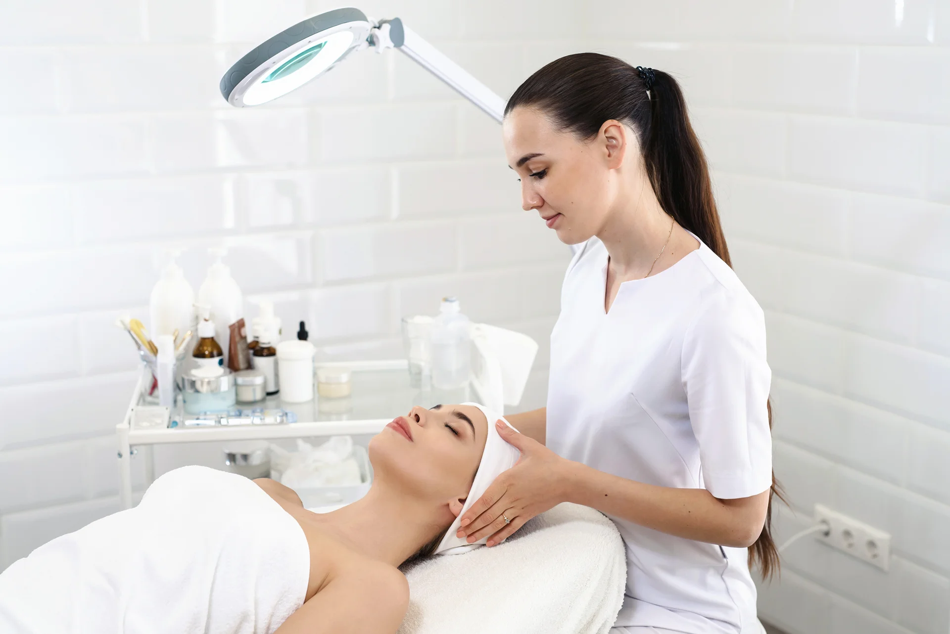 esthetician performs facial treatment on her client