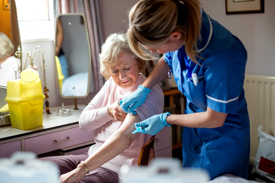 a nurse uses butterfly needle on an elderly patient