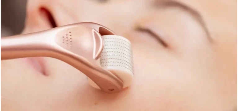 a woman uses derma roller on her face