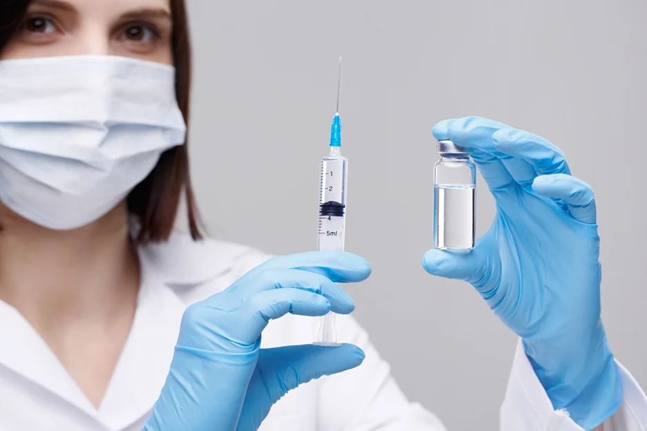 a woman holding a syrine and a vial of PDRN