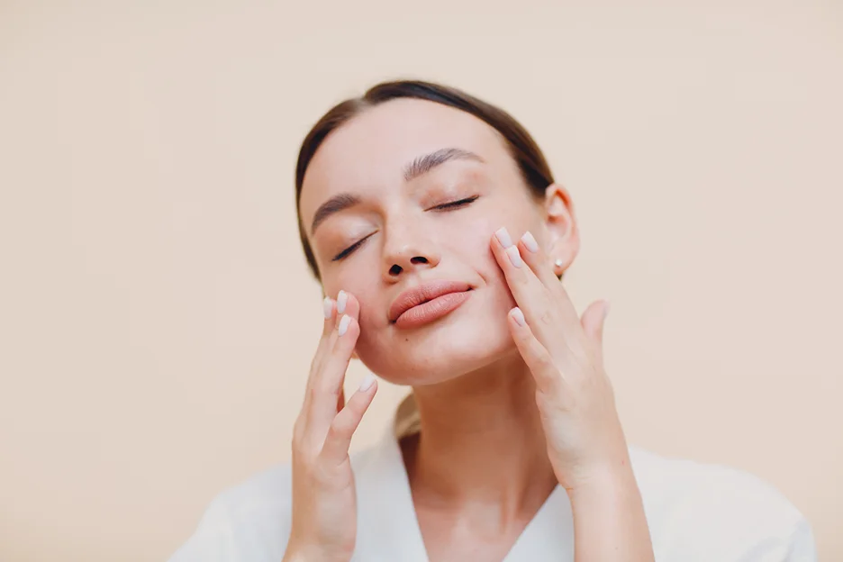 a woman touches her face after polydeoxyribonucleotides therapy