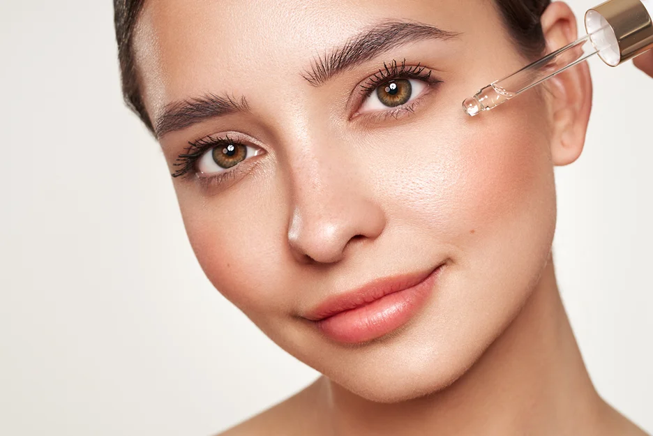 a woman applies salmon dna serum on her face