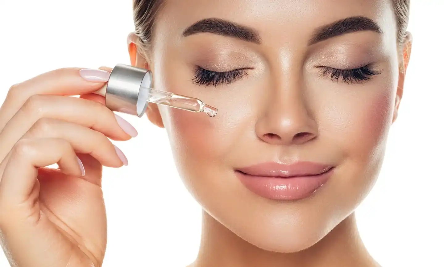 a woman applies salmon dna serum on her face