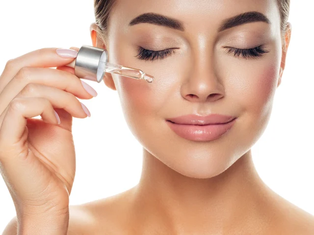 a woman applies salmon dna serum on her face